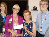 Left to right: Clinical Director for Rehabilitation Programs Mental Health Care Line Jodi Frederick watches as Jennifer S. Gutowski, Associate Director, Tucson VA Medical Center, is presented a check for $10K by TWOQC President Peggy McGee to be used for furniture for homeless veterans as they move into housing. Dr. Timothy Muller Chief, Mental Health Care Line, looks on.