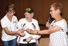 Honor Flight coordinator Kathy Mansur and WWII Veteran Helen Glass receive $1000 check from TWOQC President Peggy McGee.