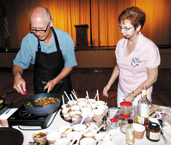 Chris Tyler watches as Randy Wade stirs rum and cinnamon into the Bananas Foster; photo by Eileen Sykora