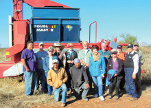 Quail Creek residents and friends share a moment with traditional flood irrigation Tohono O’odham farm team. The red monolith in the background is a Double Master II edible tepary bean harvesting combine.