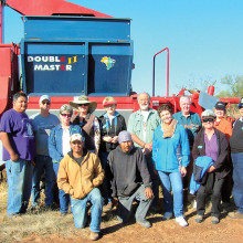 Quail Creek residents and friends share a moment with traditional flood irrigation Tohono O’odham farm team. The red monolith in the background is a Double Master II edible tepary bean harvesting combine.