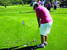 Patti Hall squares up to putt around some disposable razors; photo by Fred Waggoner.