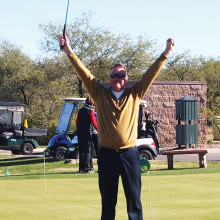 Golf Pro Joel Jaress raised his putter in victory when he got a hole-in-one on his 18th try; photo by Sylvia Butler