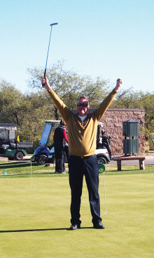 Golf Pro Joel Jaress raised his putter in victory when he got a hole-in-one on his 18th try; photo by Sylvia Butler