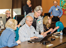 Nancy Lammers, club treasurer, helps club member use the new computerized system for signing up.