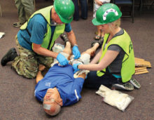 Karl Holmstrom and Rachel Ramsower tend to victim Doug Dorsey’s many injuries during a recent CERT training class; photo by John McGee.