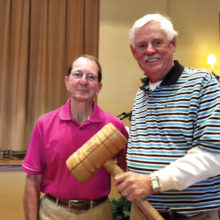 Outgoing President of the QCMGA Skip Fumia passes the gavel to incoming President Tim Phillips at the annual meeting.