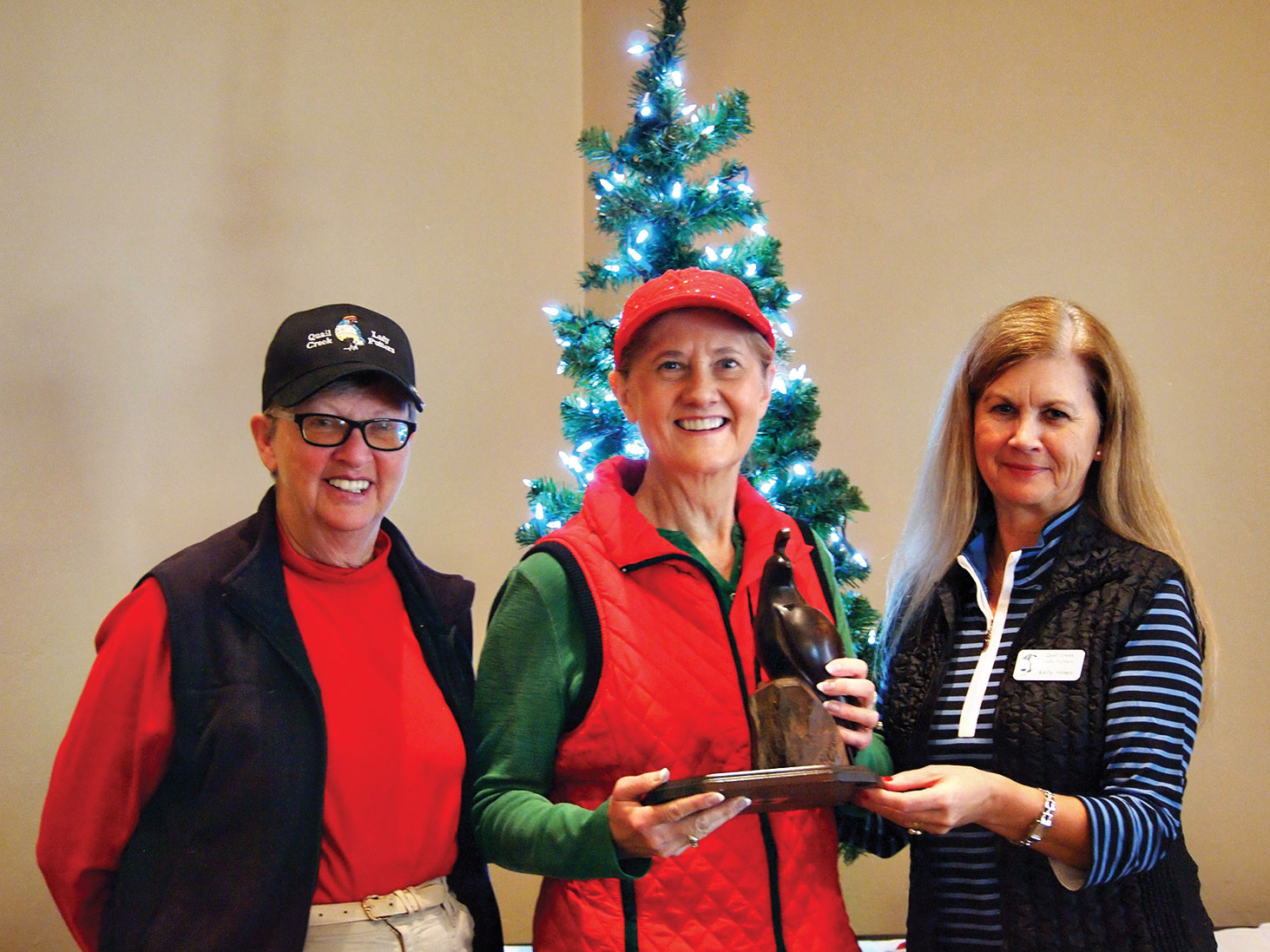 Cathy Thiele (left) and Kelly Hines congratulate Dorothy Klemme (center) as she holds the Coveted Quail for achieving a Low Net Score of 30.30; photo by Sylvia Butler