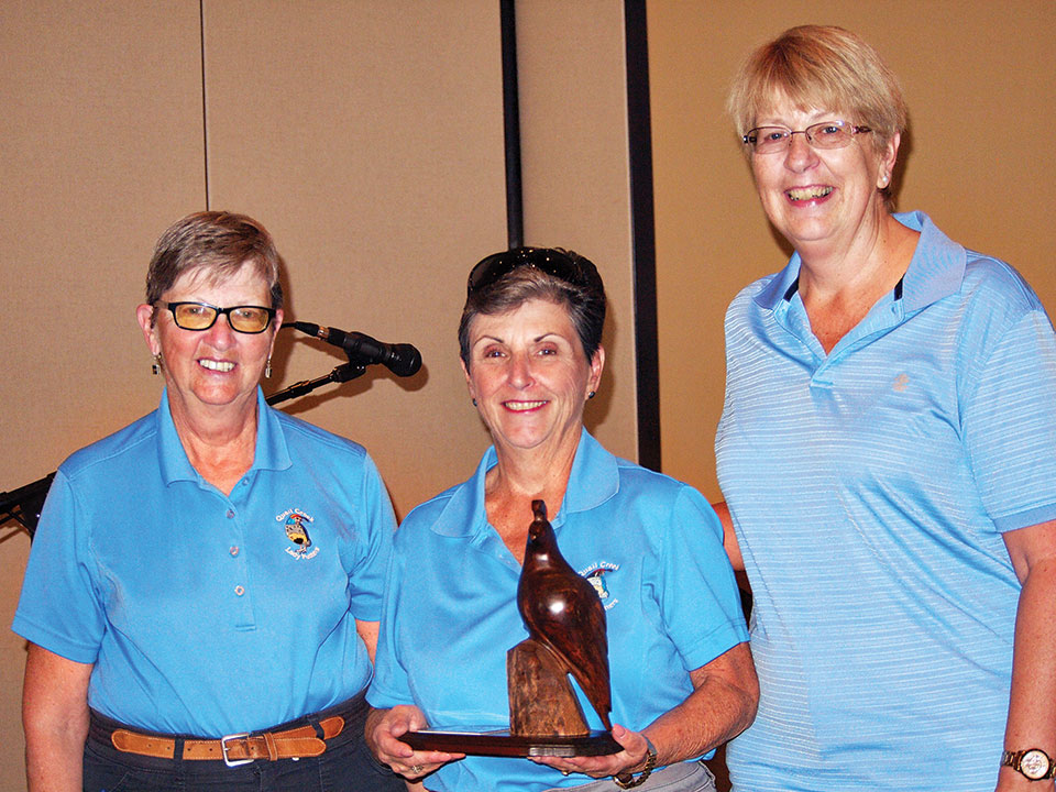Left to right: Cathy Thiele joins Coveted Quail winner Kathy Guy while Janet Wegner offers her congratulations; photo by Sylvia Butler.