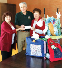 Daniel Ray of the Quail Creek Veterans’ Golf Association presents a check to baby shower co-chairs Kathi Krieg (left) and Pam Rodgers.