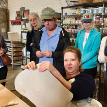 Donna Stoner demonstrates how to make clay the correct leather-like consistency and thickness for cutting shapes. The shapes, when finished, will become part of one of Santa Teresa’s colorful mosaics.