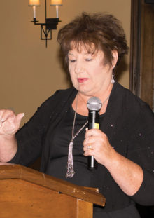 Pam “Alexa Trebek” Rodgers reveals an answer for contestants from the game board. Photo by Eileen Sykora