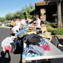 Volunteers sort men’s clothing during last year’s drive. Photo by Eileen Sykora