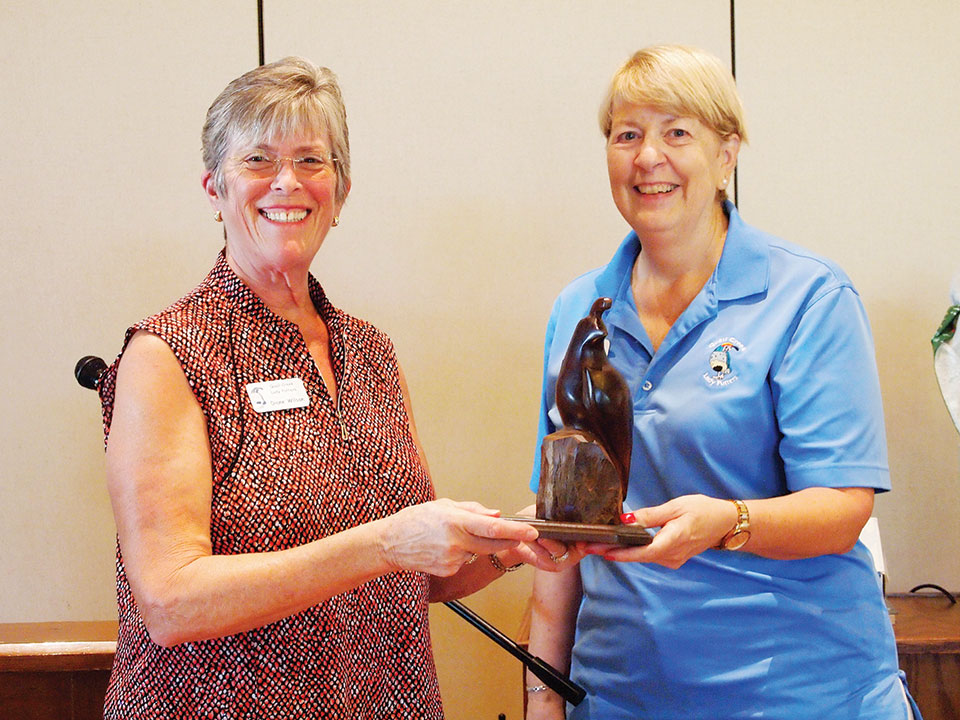 Diane Wilson (left) is awarded the Coveted Quail by Janet Wegner for her Low Net score of 30.0; photo by Sylvia Butler