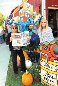 Mary Greer and Darlene O'Leary share a moment with the Blue Moose at an apple barn in upstate New York.