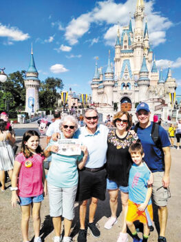 Judy and Paul White along with their fabulous grandkids taking in the Magic Kingdom while reading the Crossing.