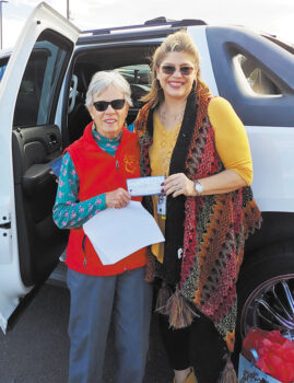 On behalf of the Lady Putters, Peggy McGee (left) presents a check for $200 to Karen Kuciver, founder of Women Warriors; Photo by Consuelo Williams.