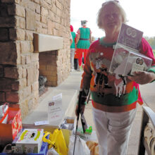 Pam Schroeder holds up the collection jar containing $450 in cash, check, and credit card donations; Photo by Peggy McGee.