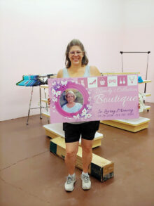 Karen Kuciver holds the Wendy's Boutique sign as she begins work on organizing the thrift shop. (Photo by Peggy McGee)
