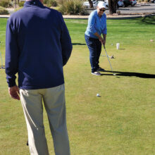Joel Jaress coaches Linda Weissman on the importance of swing length when putting. (Photo by Janet Wegner)