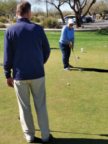 Joel Jaress coaches Linda Weissman on the importance of swing length when putting. (Photo by Janet Wegner)