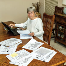Screening team member Marilyn Burkstrand reviews applications, both online and in hard copy, to make her recommendation for which women should be scheduled for an interview. (Photo by Jim Burkstrand)