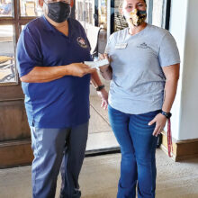 Rene Gill, QCVGA president, presents a check to TROT development director, Margaux DeConcini.