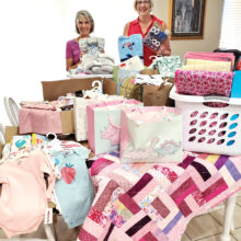Karen Baker (left) was so pleased not only with the quantity but also the variety of baby items delivered by the Lady Putters president, Janet Wegner. (Photo by Jane Herum)