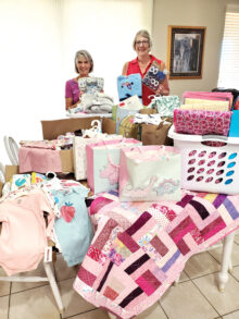 Karen Baker (left) was so pleased not only with the quantity but also the variety of baby items delivered by the Lady Putters president, Janet Wegner. (Photo by Jane Herum)